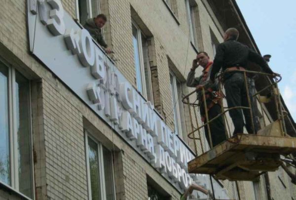 Демонтаж вивіски обласної лікарні збоку